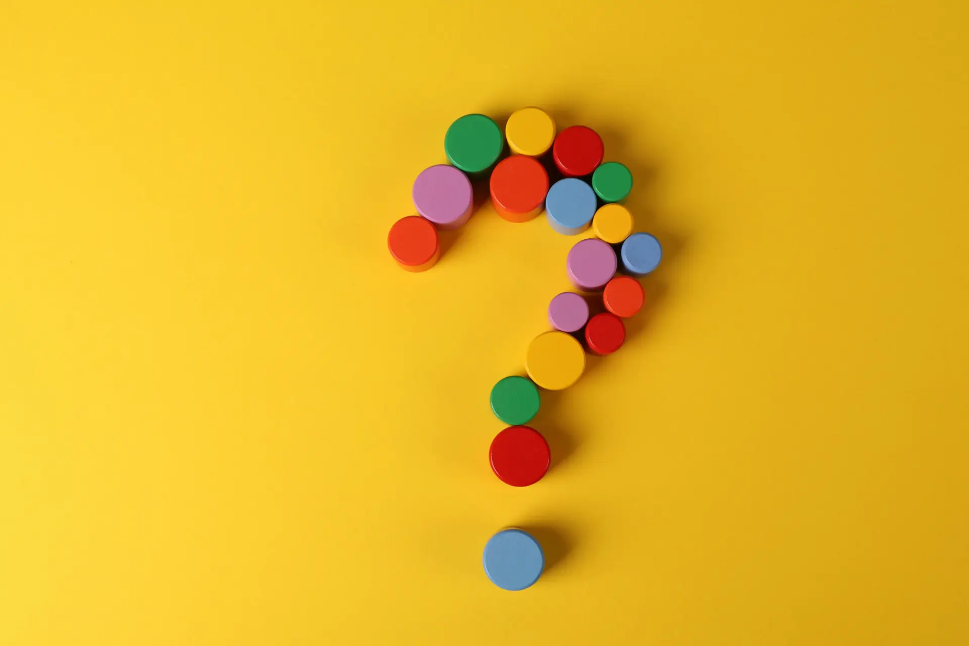 Wooden FAQ letters held by colorful toy figures | VanzaX